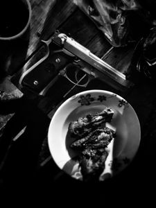 Sinaloa table with pistol and chicken wings. (Nick Quested)