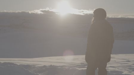 Sarah-McNair Landry stands at sunset in a snowy landscape.  (photo credit: National Geographic /Ross McDonnell)