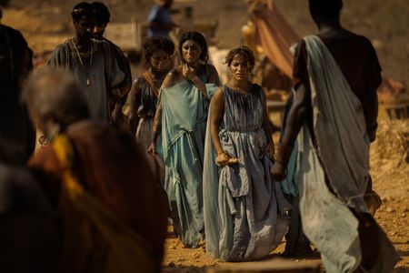 Amalthea, played by Buket Komur, stares across the Pompeii displacement camp in shock as other survivors move around her. (National Geographic/Darrin Zammit Lupi)
