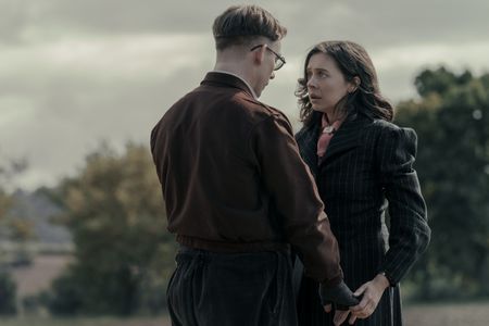 A SMALL LIGHT - Jan, played by Joe Cole, and Miep, played by Bel Powley, embrace in A SMALL LIGHT. (Credit: National Geographic for Disney/Dusan Martincek)