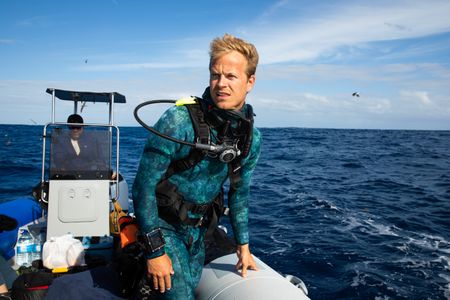Captain, Paulo Gaspar, steering the rib and host, Bertie Gregory, to the next dive site.  (credit: National Geographic/Adam Boyle)