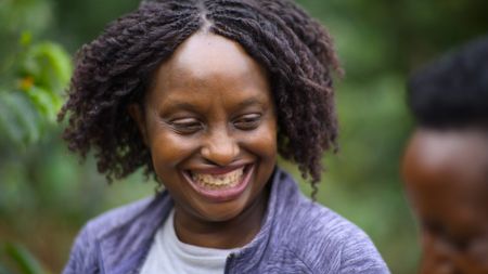 National Geographic Explorer Gladys Kalema-Zikusoka laughs during a conversation in the community setting. (National Geographic)