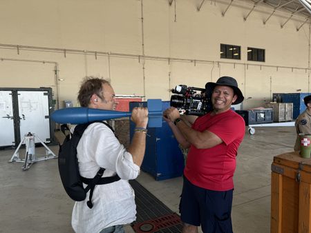 DOP Jon Southgate-Sayers holds an inert dummy bomb used in training while ground crew David Lee holds his camera. (National Geographic/Dan Di Martino)