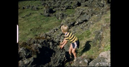 Little Andri stands by rocks on a grassy slope.   (credit: Archival Materials Courtesy of Andri Snþr Magnason)