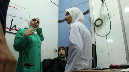 Al Ghouta, Syria - Nurse Samahar, Dr Amani and Dr Alaa working in a  subterranean hospital in Syria to save the lives of victims of chemical and conventional weapons in the Syrian Civil War. (National Geographic)