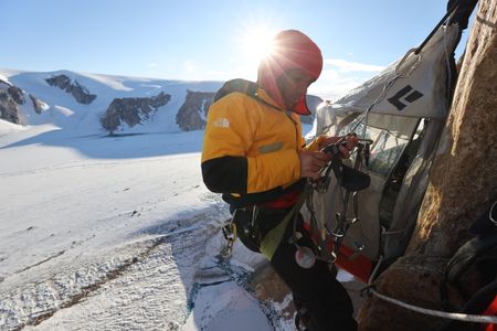 Alex Honnold checks his climbing harness and carabiners on Pool Wall in Eastern Greenland. (photo credit: National Geographic/Matt Pycroft)