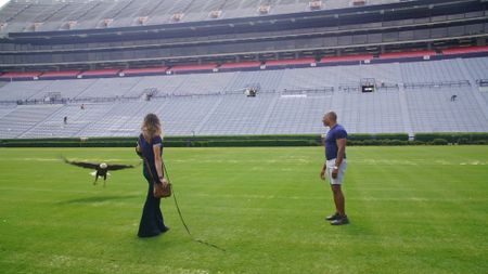 Christian Cooper admires Independence, Auburn's honorary War Eagle, during her pre-gameday flight practice with raptor trainer Amanda Sweeney. (National Geographic for Disney)