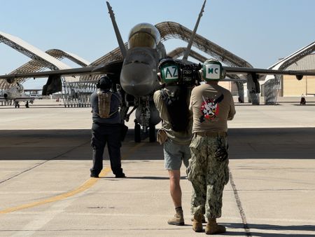 Air crew, DOP Jon Southgate-Sayers, and Naval escort Evan Parker stand in front of a returning F-18. (National Geographic/Freddie Claire)