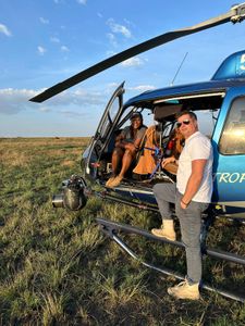 Faith Musembi and Mark MacEwan pause by the helicopter, mounted with a GSS camera, waiting to capture the action. (National Geographic/Faith Musembi)