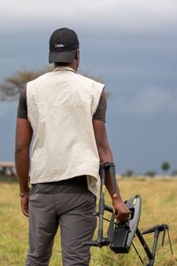 Anthony Njuguna stands with his drone. (National Geographic/Joe Treddenick)