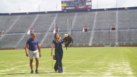 Christian Cooper assists rator trainer, Amanda Sweeney, with Independence's pre-gameday flight practice. (National Geographic for Disney)