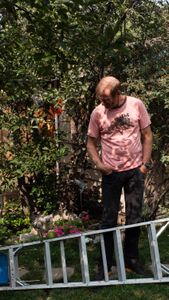 Conrad Anker stares at his chicken who is standing on a ladder.   (National Geographic/Elena Gaby)