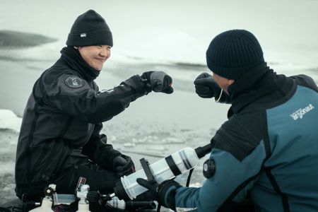 Will Smith, right, and Polar Ecologist Dr. Allison Fong fist bump following a successful dive to collect samples. (credit: National Geographic/Freddie Claire)