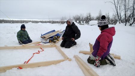Tig Strassburg builds a wood shed while his kids watch and help him work. (National Geographic)