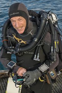 Director and cinematographer, Adam Geiger, geared up with a closed-circuit rebreather, ready to dive under a pier with the venomous Blue-ringed octopus.   (National Geographic for Disney/Harriet Spark)