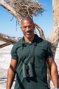 Christian Cooper stands in front of a dead tree with nests that used to be homes to Great Blue Herons. The Salton Sea has long been a vital stop for migrating birds. (National Geographic/Jon Kroll)