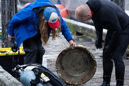 Sarah McDonald assists Troy Brockway as he scuba dives, searching for potential helpful sunken treasures. (National Geographic/Kelly Robertson)