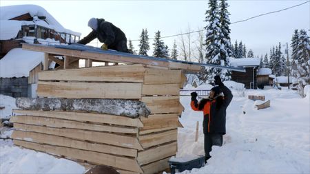 Tig Strassburg builds a wood shed while his son, Evan helps him work. (National Geographic)