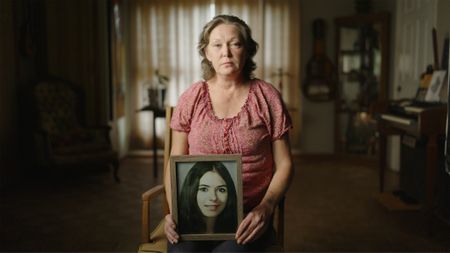 Michelle Bate holds a photo of her cousin-in-law, Sindy Gina Crow. (National Geographic/Will Francome)