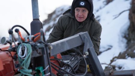 Denise Becker helps Andy Bassich take their boat out of the Yukon River before it freezes for winter. (BBC Studios/Ben Mullin)