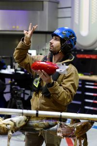 Eric Stackpole holds a camera tag and signals to crew inside of the Sub Hangar. (National Geographic/Mario Tadinac)