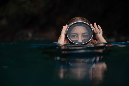 Dr Alex Schnell adjusts her dive mask on the surface while snorkeling in Lembeh Strait.  (National Geographic for Disney/Craig Parry)