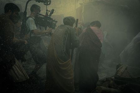 A camera operator films supporting actors fleeing through Pompeii city streets as heavy ash falls from the sky, behind-the-scenes of Pompeii: Out of Time with Tom Hiddleston. (National Geographic/Darrin Zammit Lupi)
