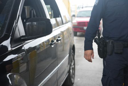 A CBP officer stands next to their booth at the Brownsville, Texas border, waiting to inspect the next traveler's documents in Brownsville, Texas. (National Geographic)