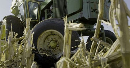 The green tractor gets stuck in the mud while Charles Pol and Ben Reinhold attempt to plant the hayfield. (National Geographic)