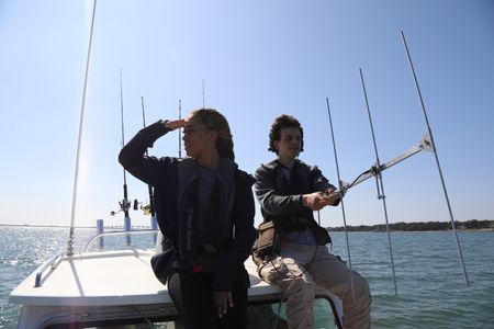 Students Beckham La Rose and Kaelyn Heits looking out to sea and using tracking equipment on board boat. (National Geographic/Mariana Kneppers)