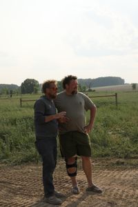 Ben Reinhold and Charles Pol, in a leg brace, watch the team work on a swale to prevent flooding around the sheep hut. (National Geographic)