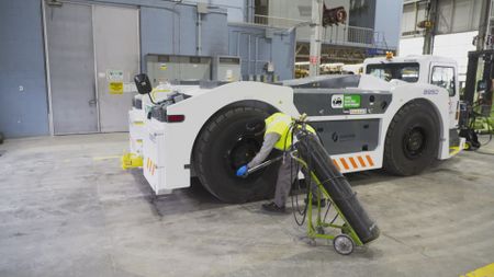 Inside the ground support workshop, Air Canada's GSE Technician, Andrew Wadhwani checks the tyre pressures on a brand new Paymover. (Arrow International Media Ltd & Cantina Media)