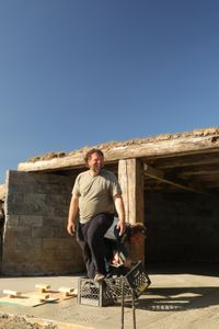 Charles Pol stands in a plastic crate to create grooves in the wet concrete as Ben Reinhold lifts and moves the other plastic crate. (National Geographic)