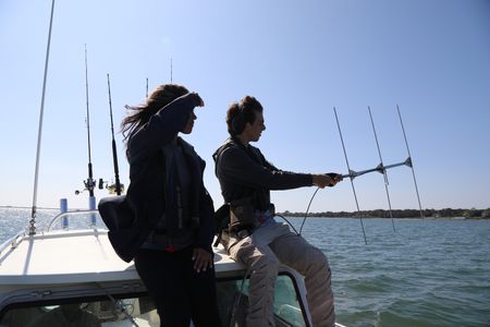 Students Beckham La Rose and Kaelyn Heits looking out to sea and using tracking equipment on board boat. (National Geographic/Mariana Kneppers)