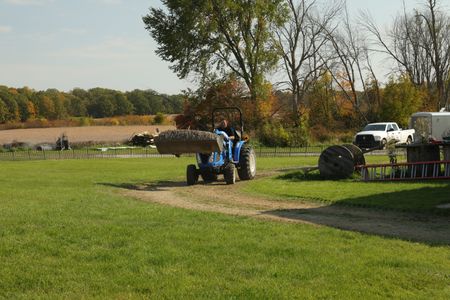 Charles Pol operates a compact tractor to transport dirt to the Pol family farm's new garden. (National Geographic)