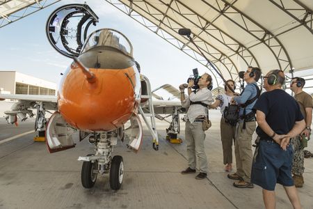 DOP Jon Southgate-Sayers, Director Lana Salah, sound recordist Phil Bax, ground personnel, and Naval escort Evan Parker getting cockpit shots of the T-45 Goshawk. (National Geographic/Freddie Claire)