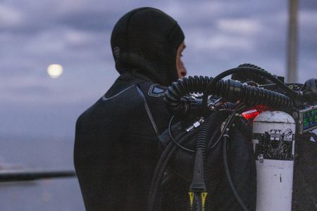 Director and cinematographer, Adam Geiger, gearing up for a CCR night dive in Port Phillip Bay.  (photo credit: National Geographic/Harriet Spark)