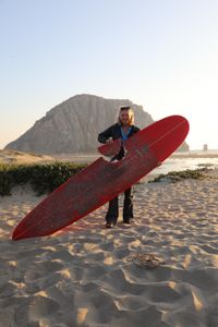 Elinor Dempsey holding up her shark-bitten surfboard. (National Geographic/Mariana Kneppers)