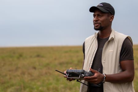 Drone Pilot Anthony Njuguna operates the drone, capturing aerial footage of Summer's Pride in action. (National Geographic/Joe Treddenick)