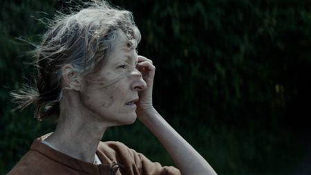 A female villager stands in a field looking out to the distance in disconcern. (Dash Pictures/Samuel Purcell, Oliver Watts)