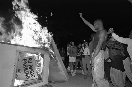 Rioters near Parker Center, LAPD headquarters in downtown Los Angeles, over turn a parking kiosk and set it ablaze. Los Angeles has undergone several days of rioting due to the acquittal of the LAPD officers who beat Rodney King. Hundreds of businesses were burned to the ground and over 55 people have been killed. (Photo by Ted Soqui/Corbis via Getty Images)