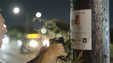 Detective David Turner of Smith County Sheriff's Office puts up an unidentified person's poster of Jane Doe's facial reconstruction near the Harry Hines Boulevard in Dallas. (National Geographic/Will Francome)