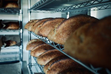 Whole wheat sourdough loaves cool on racks in Justin Gomez's basement bakery, Humble Bakehouse, in Martinez, Calif. A cottage baker, Justin produces naturally leavened breads through his home business, Humble Bakehouse, which he named like that because nothing can humble a baker quite like sourdough. (National Geographic/Ryan Rothmaier)