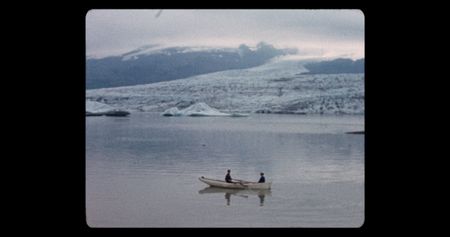 Two people on a row boat in a glacial lagoon.  (credit: Archival Materials Courtesy of Andri Snþr Magnason)