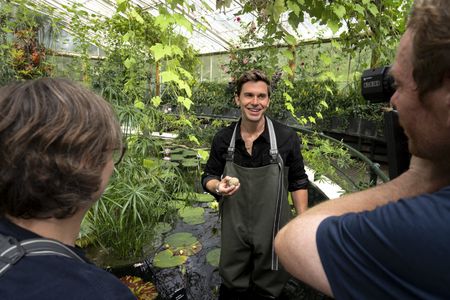 Behind-the-scenes as Antoni Porowski helps to feed the Giant waterlily at Kew Gardens near London, UK, as seen in National Geographic’s Best of the World with Antoni Porowski. (National Geographic/John Wendle)