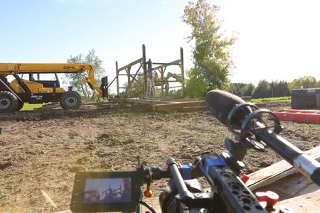 Bill Klein, Seth Doble, and Charles Pol continue to take down the remaining beams from the old barn as a crew member films them. (National Geographic)