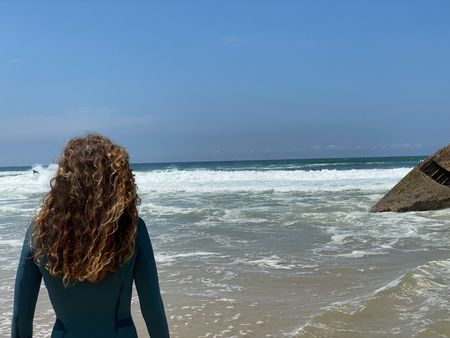 Big wave surfer Justine Dupont, wearing her wetsuit, admires the sea.  (National Geographic/Gene Gallerano)