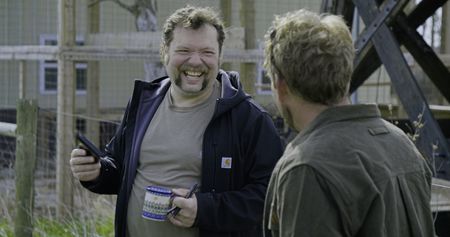 Charles Pol drinks coffee with Ben Reinhold in the field at Pol Family Farm. (National Geographic)