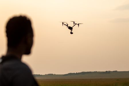 Behind-the-scenes as Anthony Njuguna flies a drone while filming. (National Geographic/Joe Treddenick)