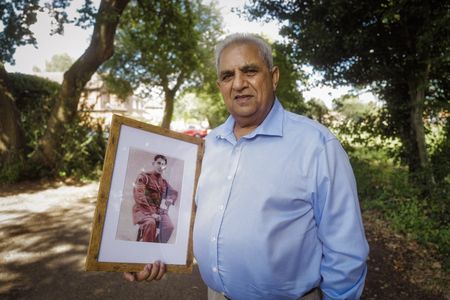 Mohammed Zubair holds a portrait of his father, Chaudry Wali Mohammad, while visiting a memorial garden in London. Corporal Chaudry Wali Mohammed was a member of Force K6, an Indian Regiment of mule handlers in WW2. Amidst the chaos of Dunkirk and the advancing German Army, one little-known Indian Regiment fights for victory and independence. (National Geographic/Daniel Dewsbury)